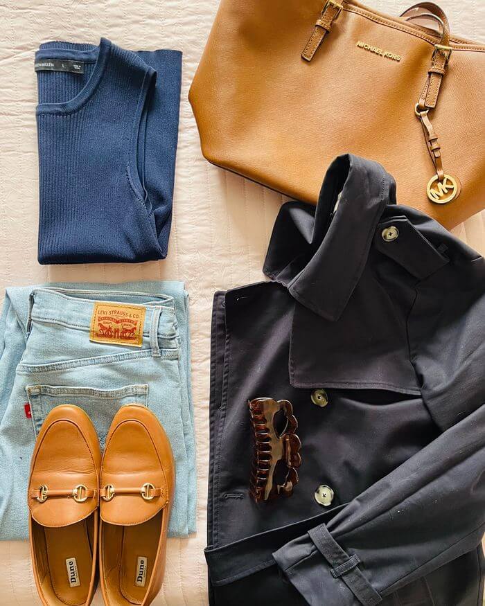 a navy blue vest top with blue jeans and a brown bag and brown loafers